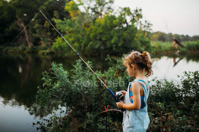 Chica joven con traje de baño de pesca en arroyo durante el verano - foto de stock