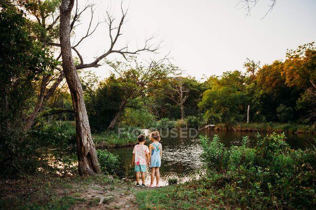 Милий хлопчик і дівчинка біля озера — стокове фото