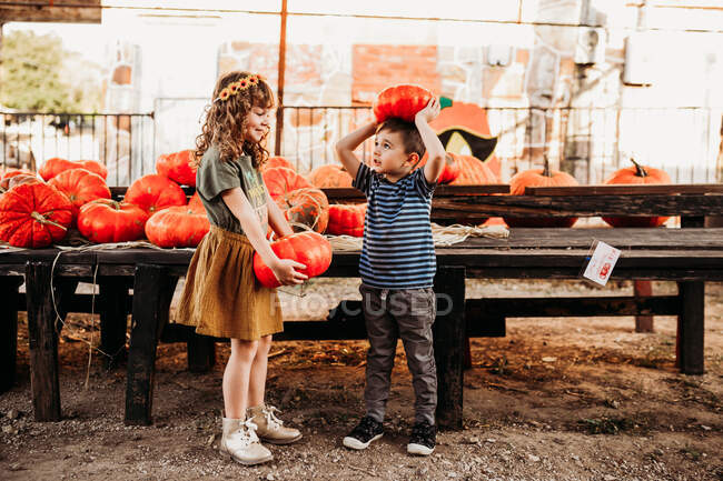 Милый мальчик и девочка с тыквами — стоковое фото