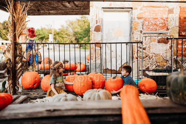 Cute boy and girl with pumpkins — Stock Photo