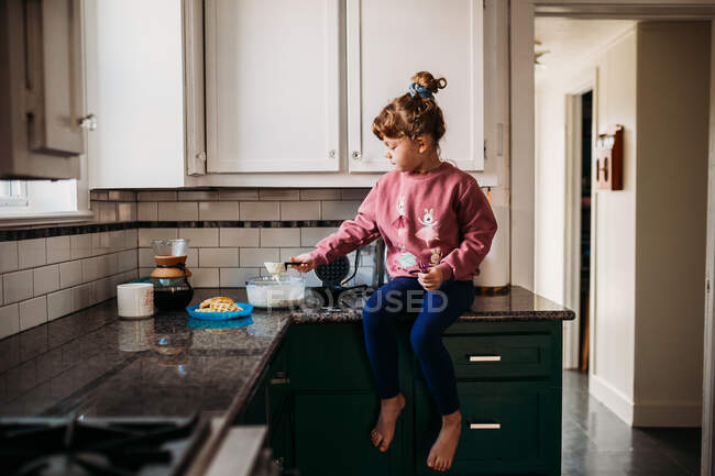 Niedliches kleines Mädchen zu Hause essen — Stockfoto