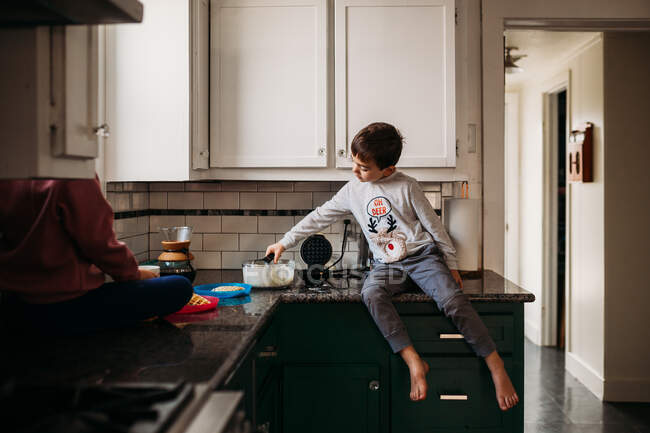 Симпатичный мальчик готовит дома — стоковое фото