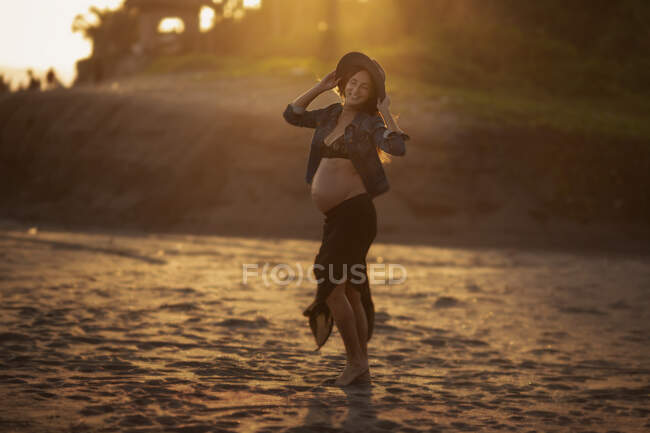 Enceinte femme heureuse sur une plage — Photo de stock