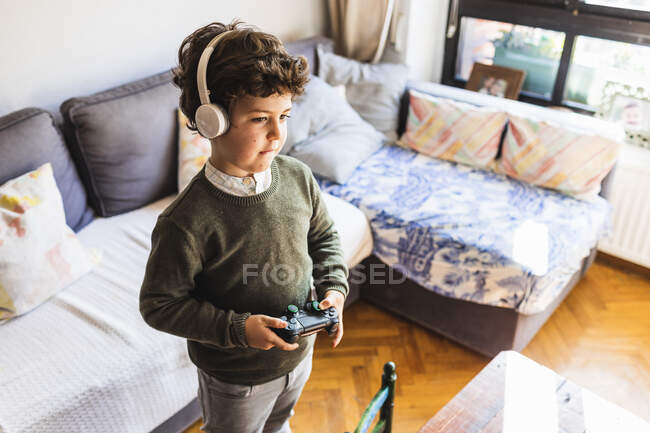 Garçon jouer à des jeux vidéo avec joystick et console — Photo de stock