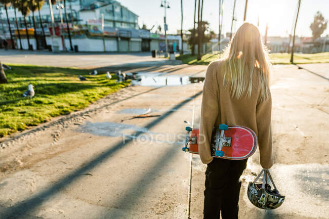 Girl walking with red skateboard — Stock Photo