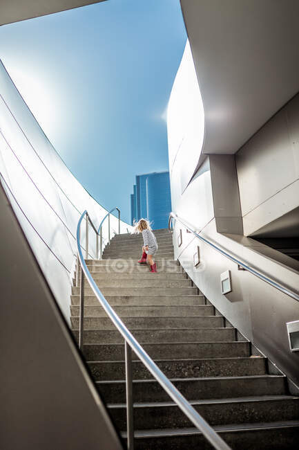 Little girl climbing up a staircase — Stock Photo