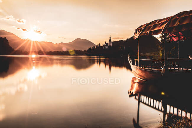 Barco en el lago Bled al amanecer - foto de stock