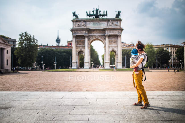 Mother carrying her baby visiting Milan — Stock Photo