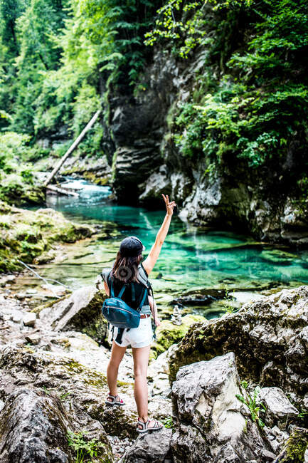 Happy woman with her arm up in a turquoise river in Vintgar Gorge — Stock Photo