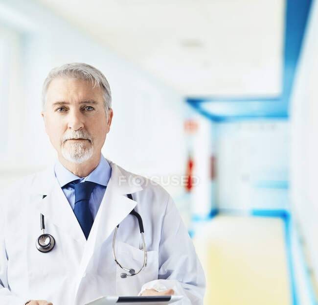 Doctor in the hospital hallway with tablet — Stock Photo