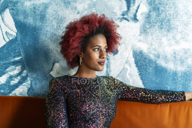 Hermosa mujer con afro cabello esperando sentado - foto de stock