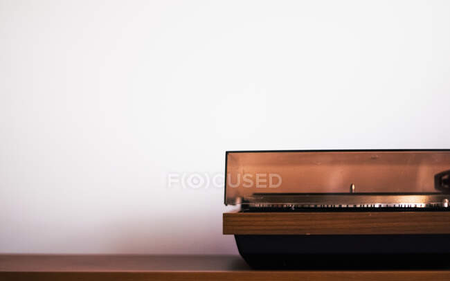 Turntable standing on the brown surface with a lot of white background — Stock Photo