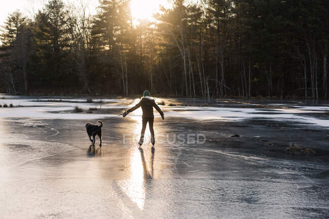 Cute boy on froze lake skating — Stock Photo