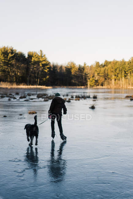 Милий хлопчик на заморожених ковзанах на озері — стокове фото