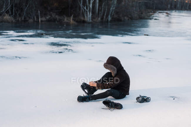 Menino bonito no lago congelado utting em patins — Fotografia de Stock