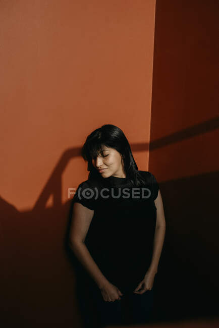 Красивая молодая женщина, позирующая у стены — стоковое фото