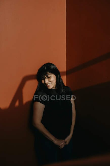 Bela jovem mulher posando por parede — Fotografia de Stock
