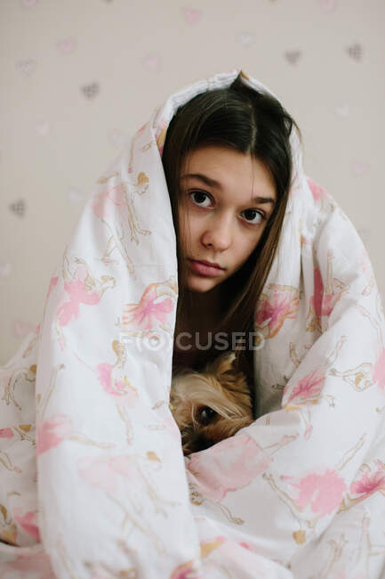 Girl and her pet covered with blanket — Stock Photo