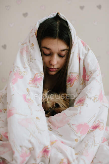 Menina e seu animal de estimação coberto com cobertor — Fotografia de Stock