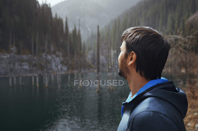 Uomo che esplora il lago di montagna di Kaindy, Kazakistan — Foto stock