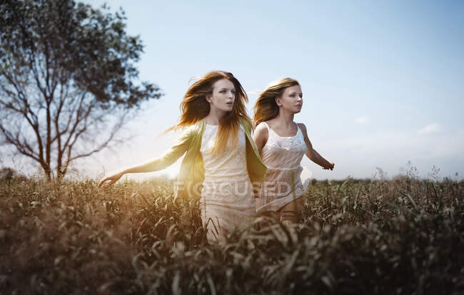 Deux femmes qui courent dans les prairies. Convient bien pour la couverture de livre — Photo de stock