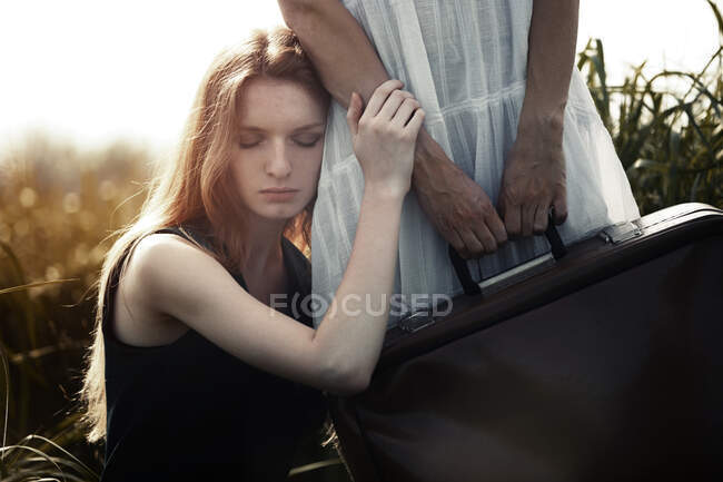 Sad woman leaning to the sister holding suitcase. Nicely fits for book — Stock Photo