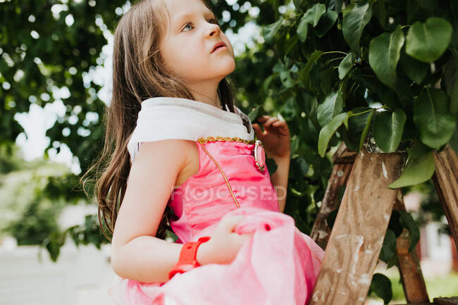 Маленька дівчинка в рожевій сукні з букетом квітів — стокове фото