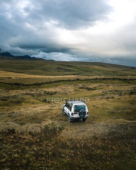 White jeep in the middle of the moutains with a beautiful sky — Stock Photo