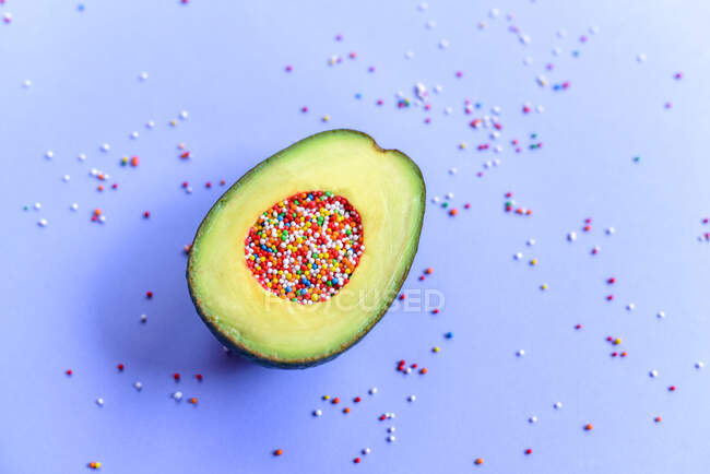 Fresh avocado stuffed with Easter sprinkle and pastry topping — Stock Photo