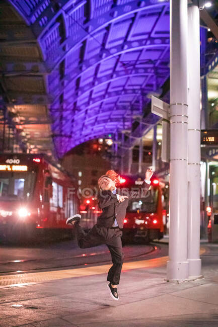 Niño bailando en una estación de tren del centro en el momento de la noche. - foto de stock