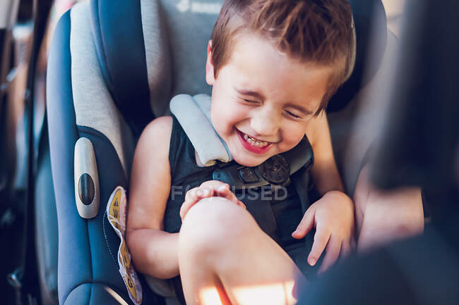 Bambino in età prescolare seduto nel seggiolino auto all'interno di una macchina. — Foto stock