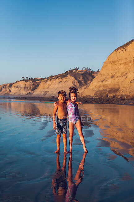 Niños lindos divirtiéndose en la playa - foto de stock