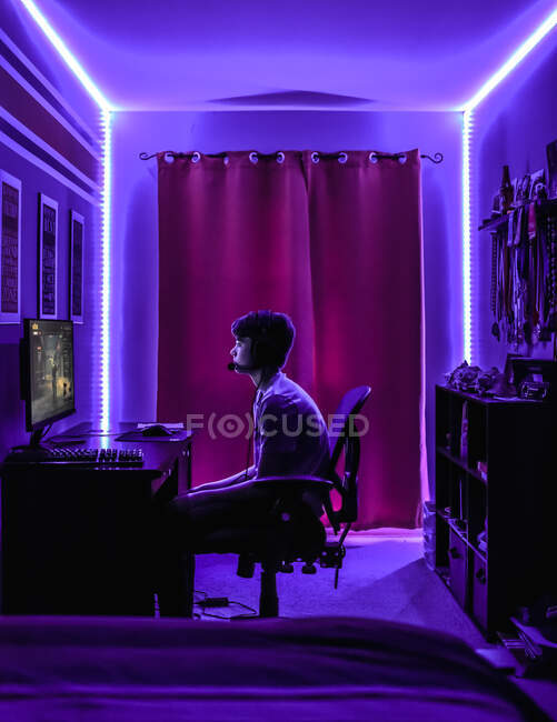 Le jeune garçon avec l'ordinateur dans la pièce — Photo de stock