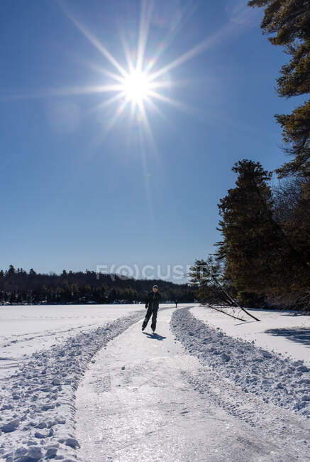 Teen boy pattinaggio su ghiaccio su un lago ghiacciato in un giorno d'inverno in Canada. — Foto stock