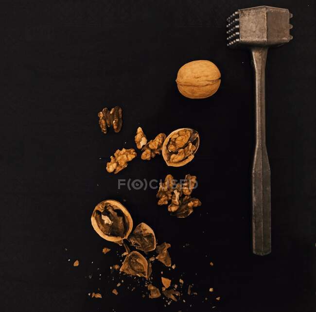 Cracked walnuts on black background — Stock Photo