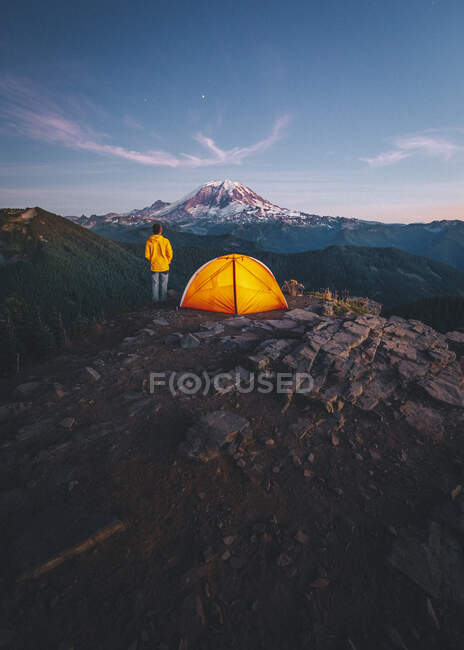 Vista de uma mulher e barraca de acampamento em um fundo de montanhas e da lua — Fotografia de Stock