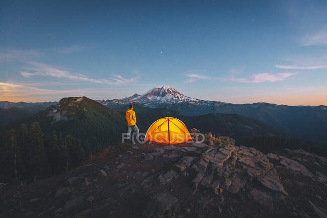Vue d'une femme et tente de camping sur fond de montagnes et de lune — Photo de stock