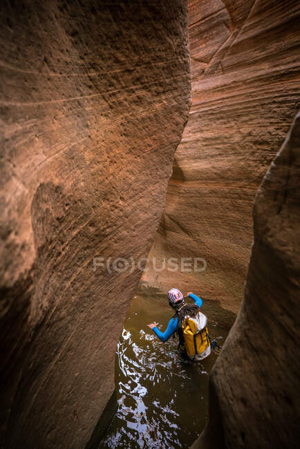 Un uomo guadagna attraverso acque profonde per navigare in un canyon slot a Sion — Foto stock