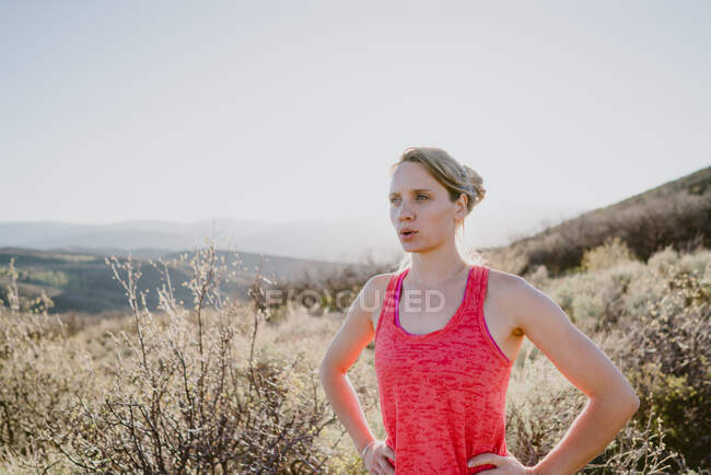 Спортсменка-блондинка дышит на тропе в горах — стоковое фото