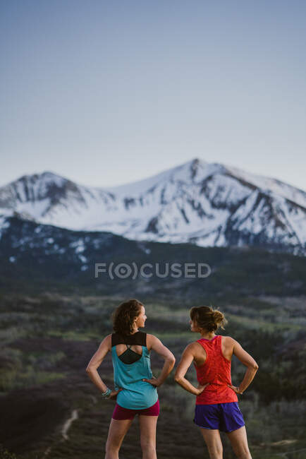Duas amigas param para conversar enquanto trilha correndo nas montanhas — Fotografia de Stock