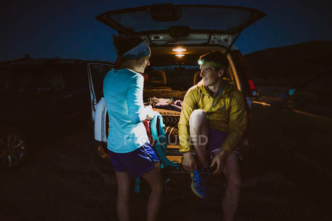 Mann und Frau sitzen und lachen nach einem langen Loipenlauf in den Bergen — Stockfoto