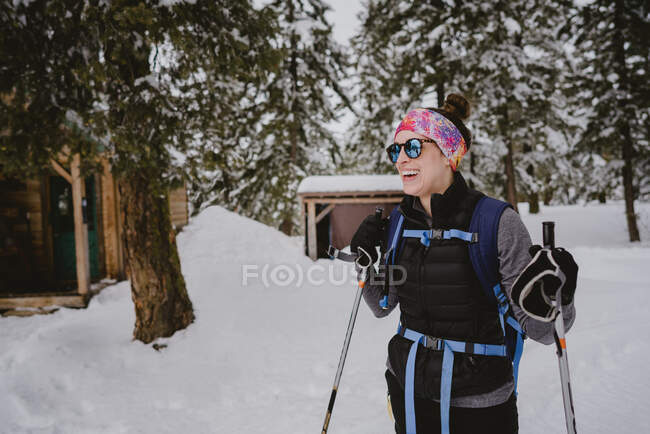 Una donna con occhiali da sole e risate gonfie mentre XC sciare in cabina — Foto stock