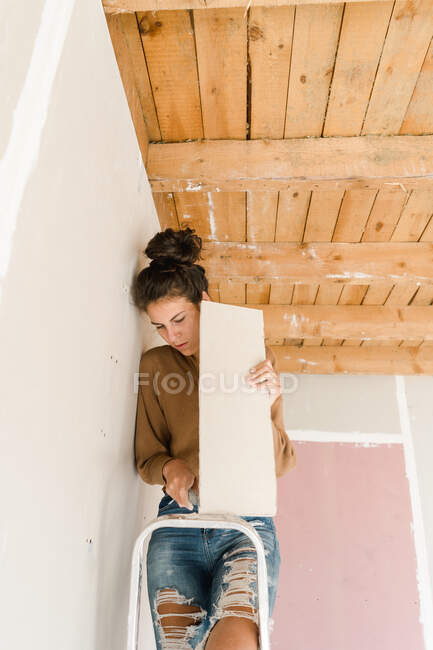 Young woman doing repair works at home — Stock Photo