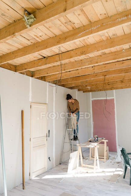 Jeune femme faisant des travaux de réparation à la maison — Photo de stock