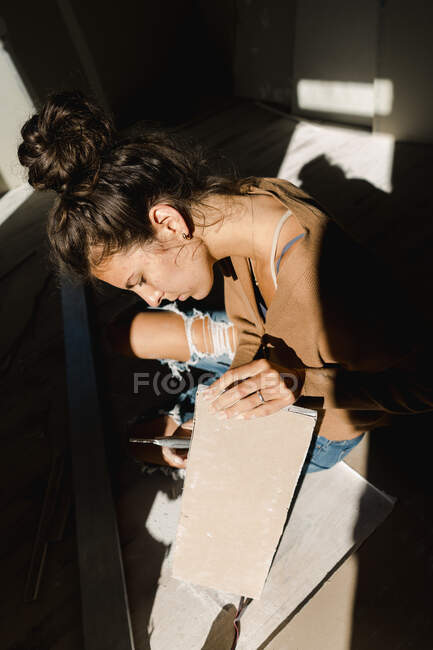 Jeune femme faisant des travaux de réparation à la maison — Photo de stock