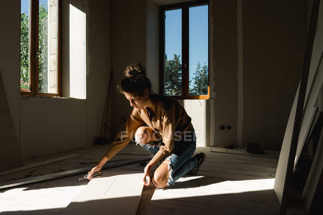 Молода жінка робить ремонтні роботи вдома — стокове фото