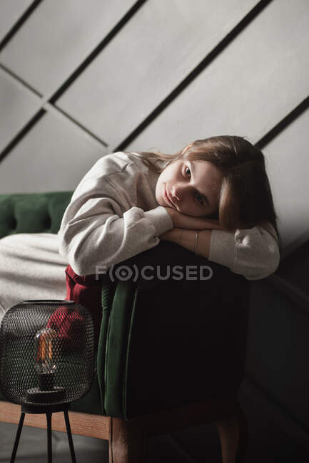 Sad girl lying on green sofa — Stock Photo