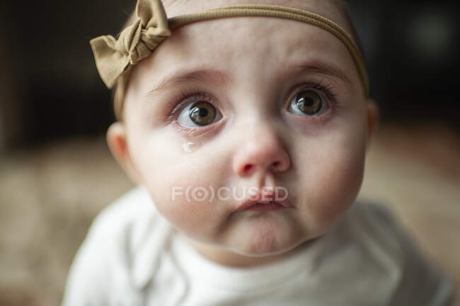 Close up of sad baby girl with pouting lips and big tearful eyes — Stock Photo