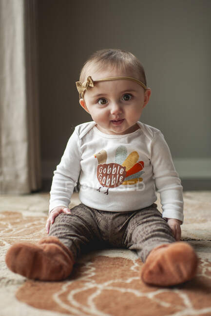 Baby Mädchen 6-9 Monate sitzt im Thanksgiving-Outfit auf Teppich zu Hause — Stockfoto