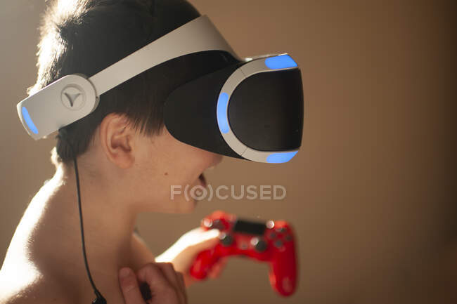 Ragazzo 9-10 anni gode di giocare a un gioco di realtà virtuale a casa — Foto stock